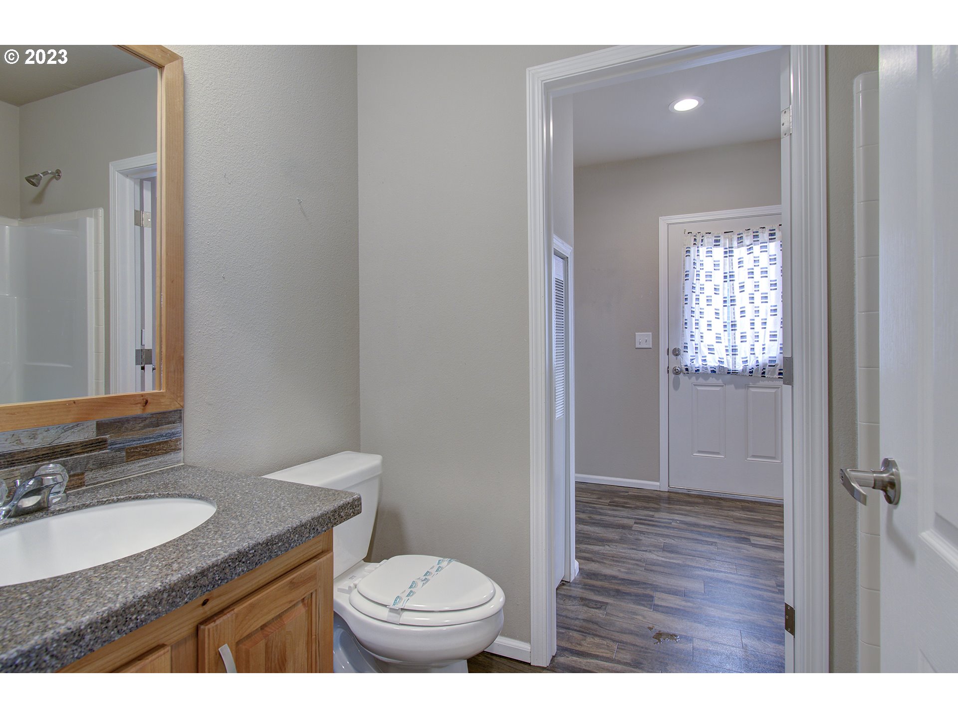 136 Stringtown Road Ilwaco, WA 98624 - Photo 24 of 47 a bathroom with a granite countertop sink toilet a mirror and vanity