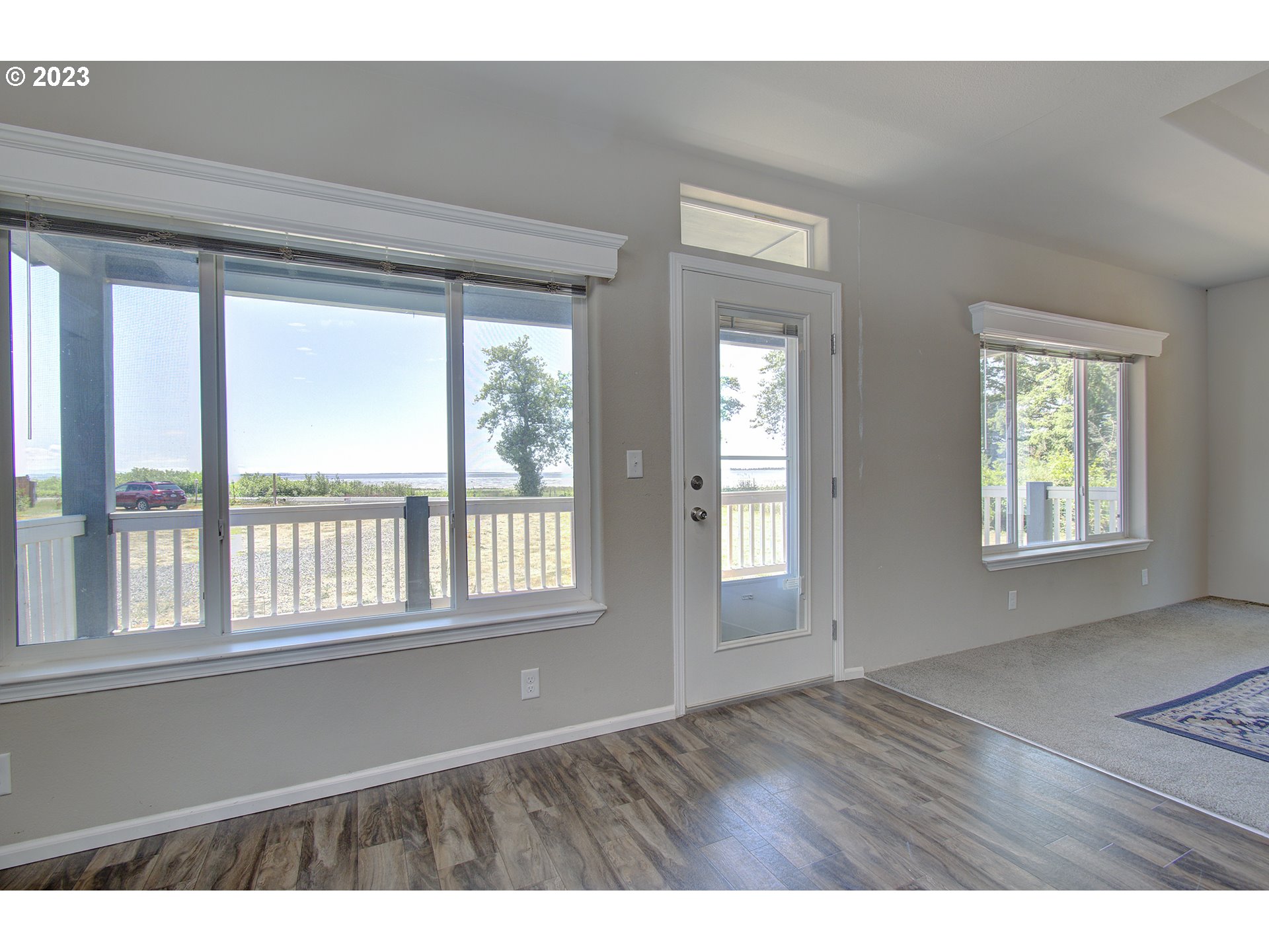 136 Stringtown Road Ilwaco, WA 98624 - Photo 9 of 47 a view of an empty room with wooden floor and a window
