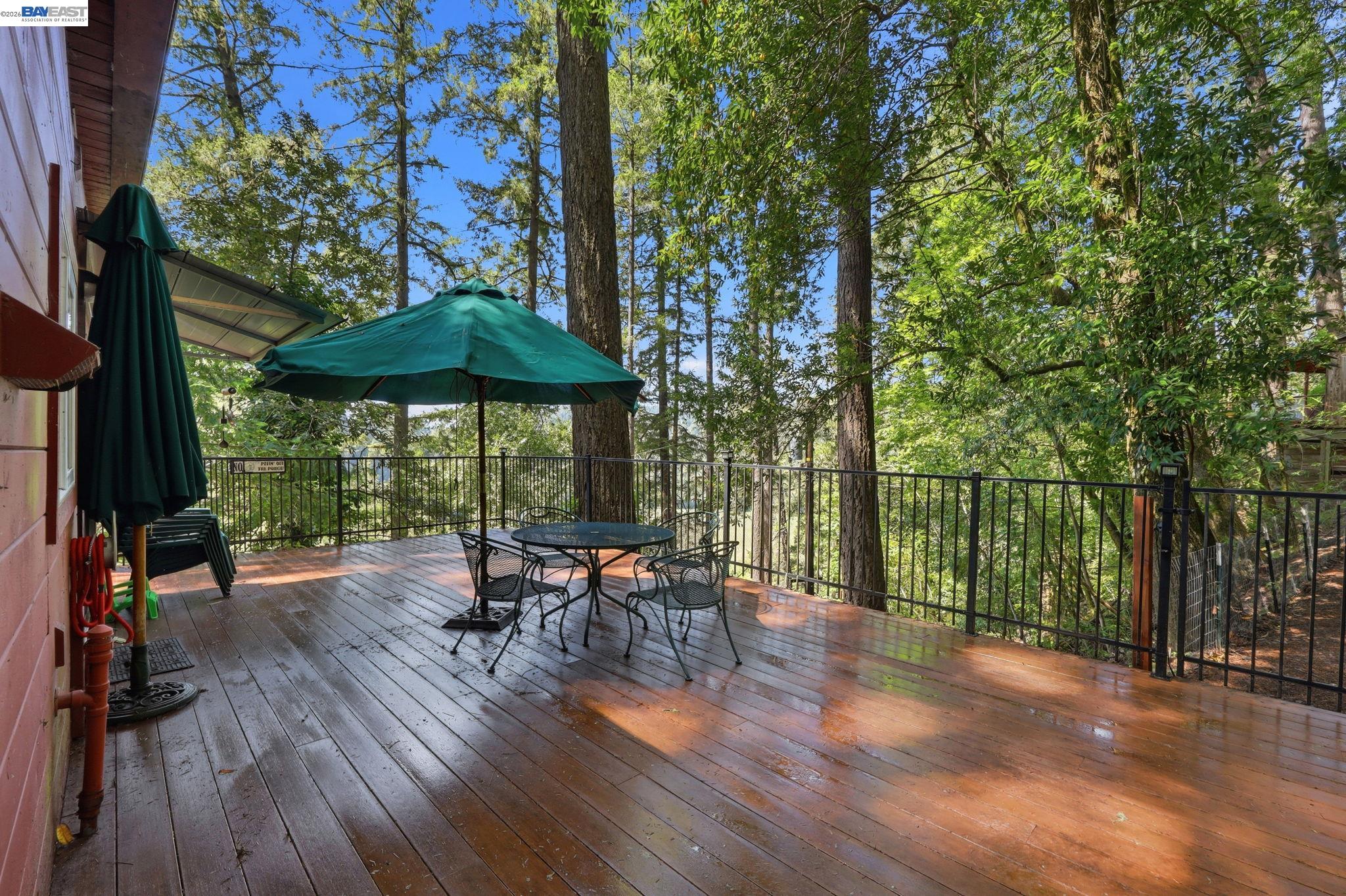 11700 Oak Road Forestville, CA 95436 - Photo 13 of 20 a view of a patio with table and chairs under an umbrella with wooden fence