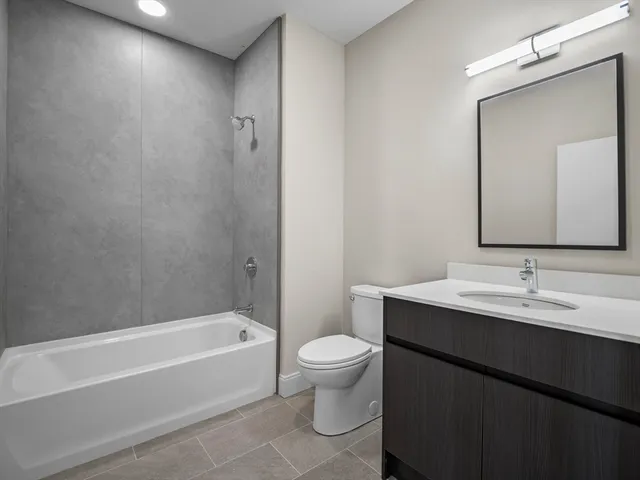 a bathroom with a bathtub a sink a toilet a mirror and vanity