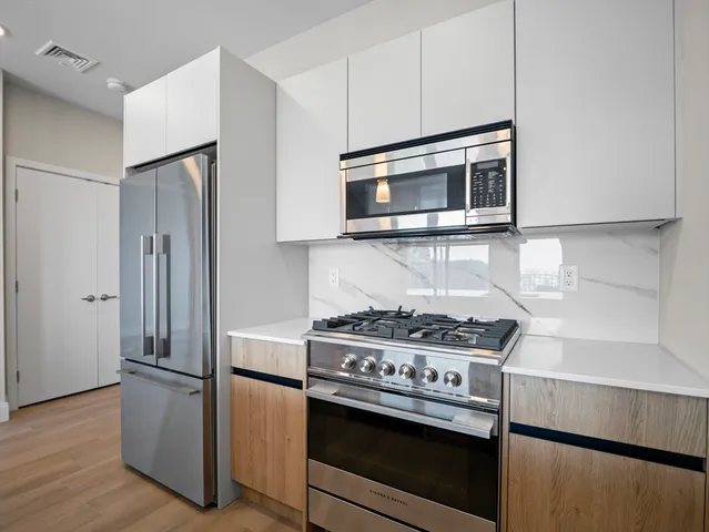 a kitchen with stainless steel appliances a stove a microwave and a refrigerator