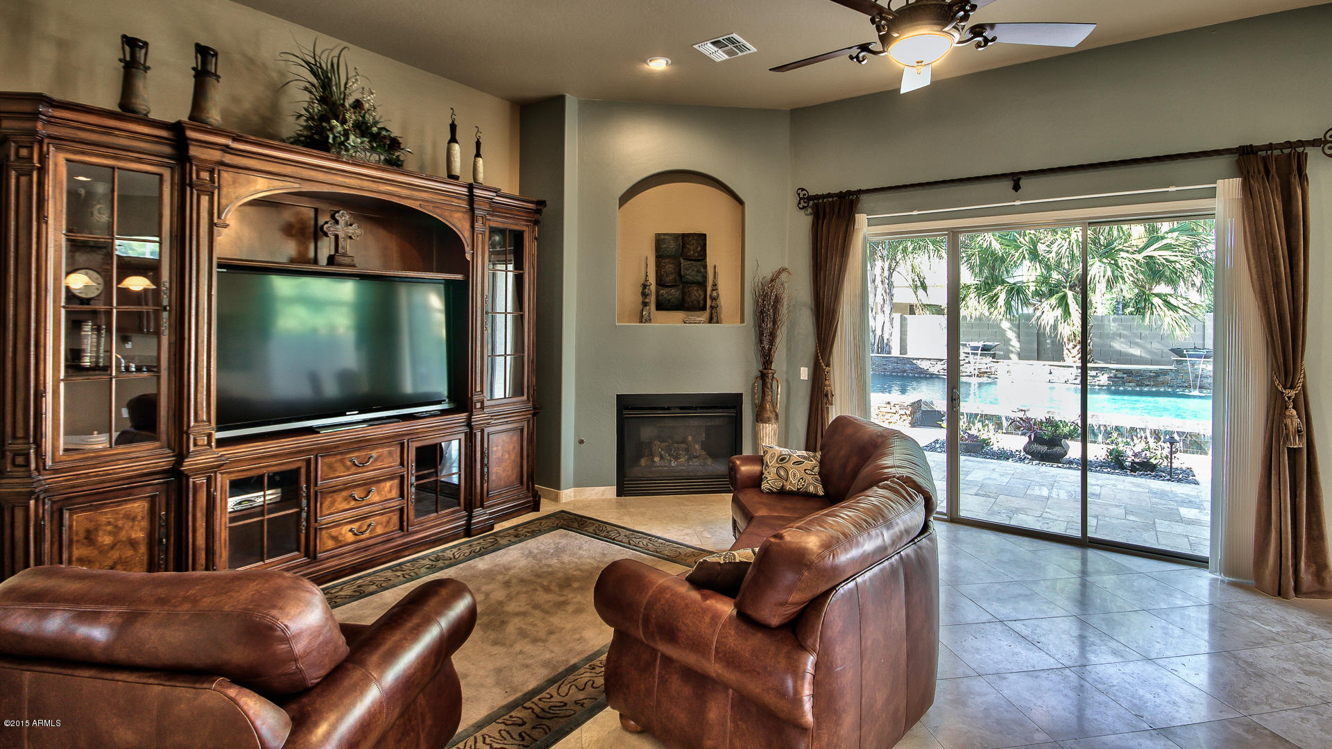 4782 East Buckboard Road Gilbert, AZ 85297 - Photo 17 of 57 a living room with furniture a flat screen tv and a fireplace