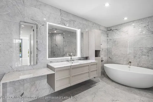 a spacious bathroom with a tub sink shower and mirror