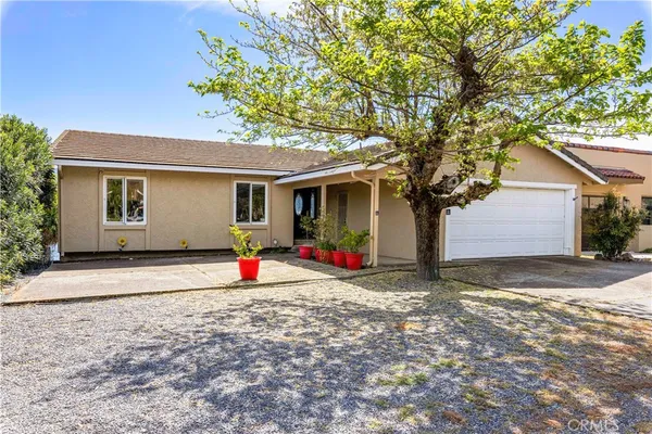 a view of a house with backyard and tree