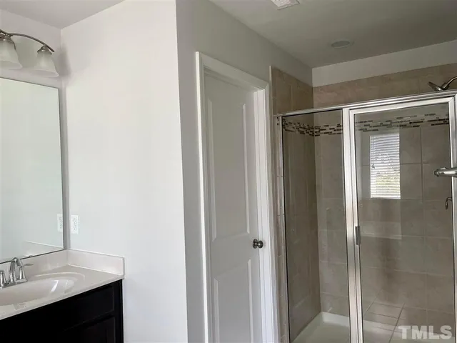 a bathroom with a shower sink and mirror
