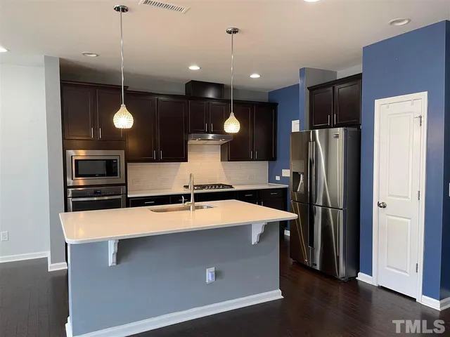 a kitchen with stainless steel appliances a refrigerator and a microwave