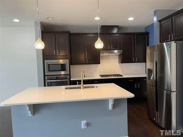 a kitchen with stainless steel appliances a refrigerator and a sink
