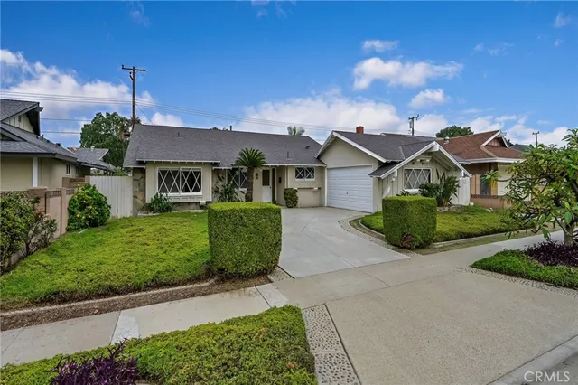 a view of a house with a big yard plants and large trees