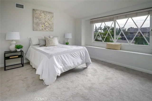 a spacious bedroom with a bed and a large window