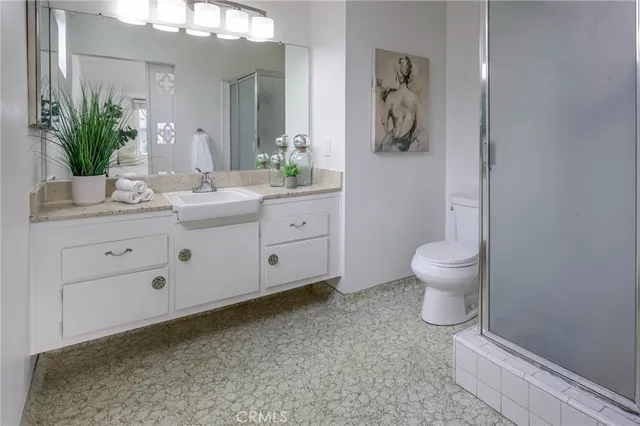 a bathroom with a granite countertop sink a toilet and a mirror