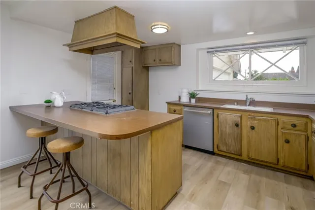 a kitchen with stainless steel appliances granite countertop a sink a stove and a wooden floors