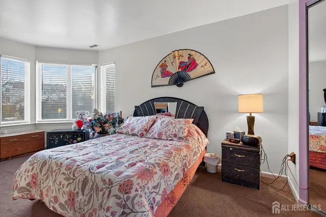 a bedroom with a bed and a large window