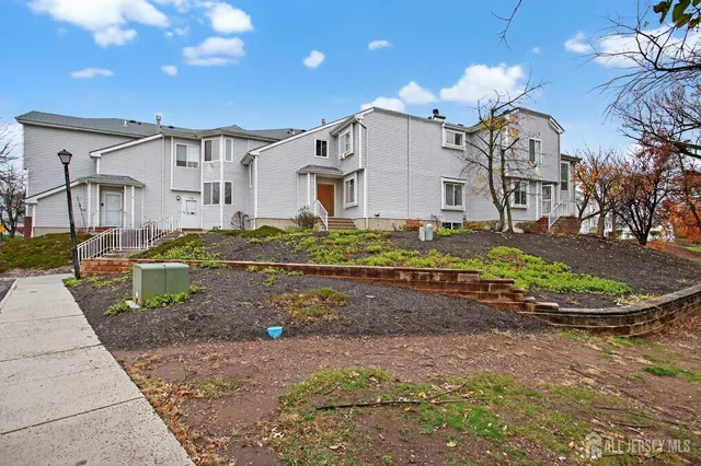 a view of a white house with a yard and plants
