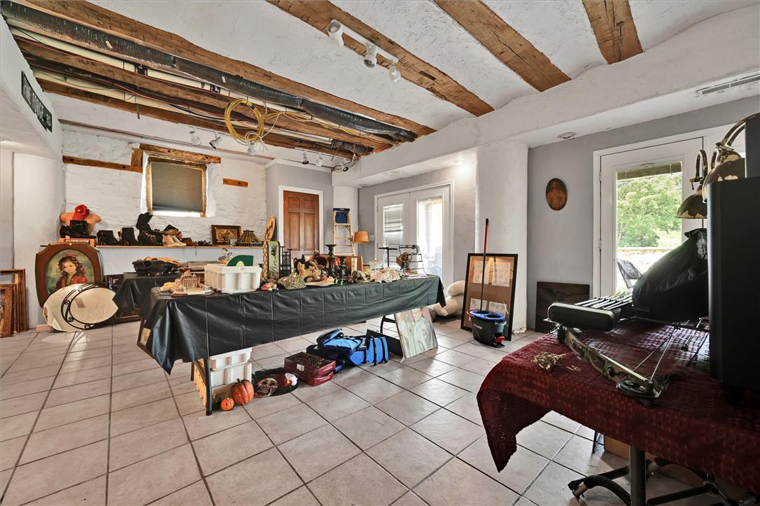 101 Conrad Road Fleetwood, PA 19522 - Photo 18 of 42 Exposed wood beams and tiled floors lend rustic appeal to this versatile basement space, illuminated by track lighting.