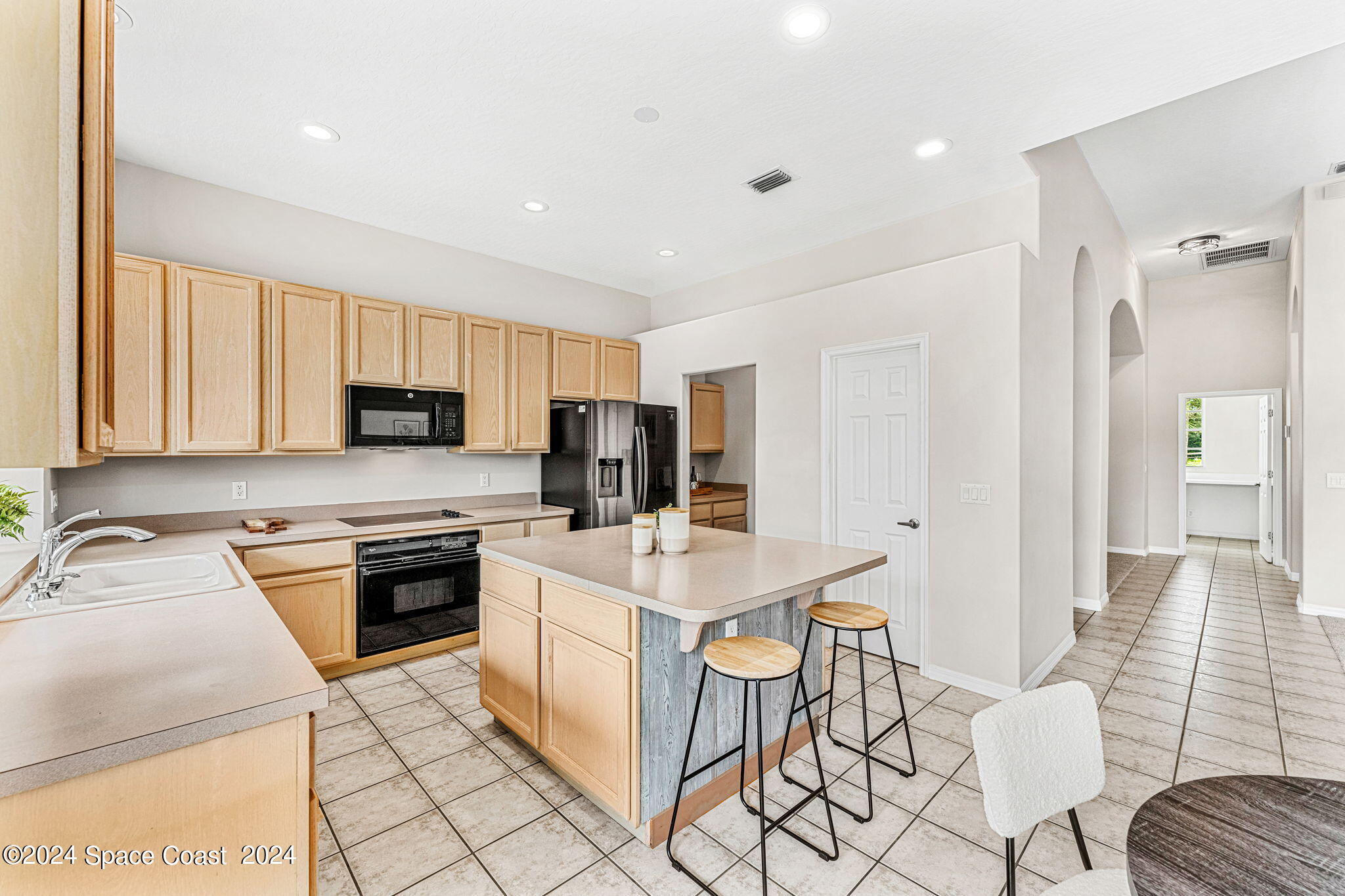 4140 Windover Way Melbourne, FL 32934 - Photo 12 of 53 a kitchen with stainless steel appliances granite countertop a stove top oven a sink a dining table and chairs with wooden floor