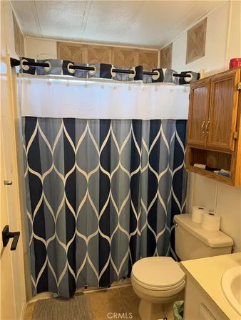 a bathroom with a sink a toilet a mirror and a shower