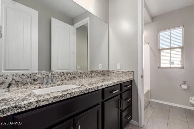 a bathroom with a granite countertop sink and a mirror