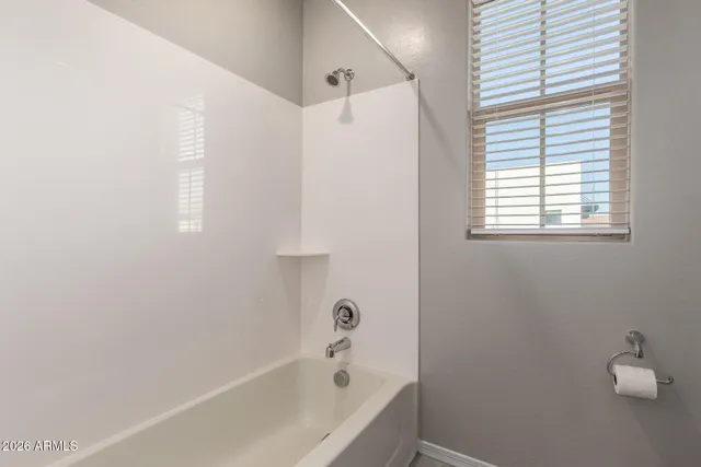 a bathroom with a bathtub a shower and a window