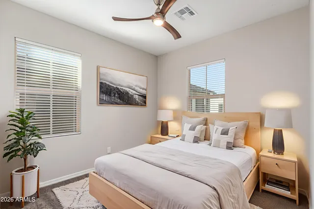 a bedroom with a large bed and a potted plant