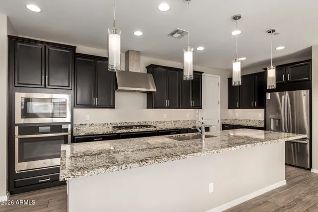 a kitchen with stainless steel appliances granite countertop a sink and a refrigerator