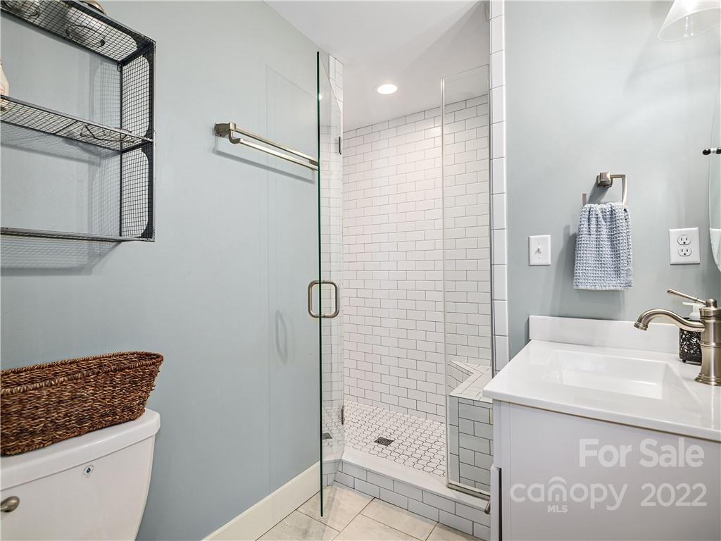 1 Inglewood Road Asheville, NC 28804 - Photo 29 of 40 a bathroom with a shower sink and mirror