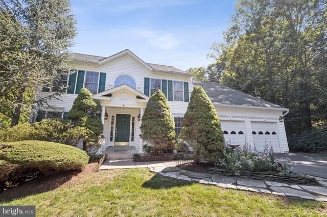 a view of a white house with a yard and large tree