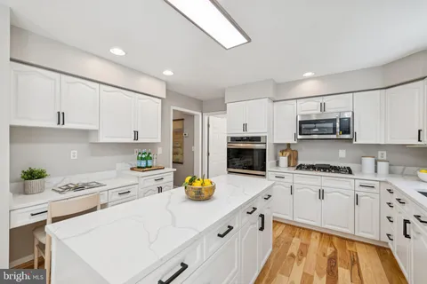 a kitchen with granite countertop white cabinets and stainless steel appliances