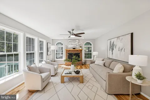 a living room with furniture large window and fireplace