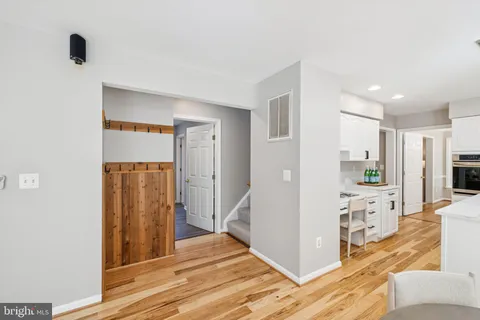 a view of a hallway with wooden floor and a living room