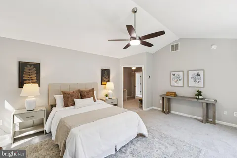 a bedroom with a large bed and a chandelier