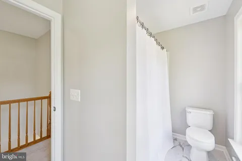 a white toilet sitting next to a shower
