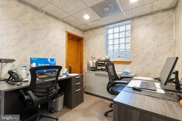 a view of a workspace with furniture and a window