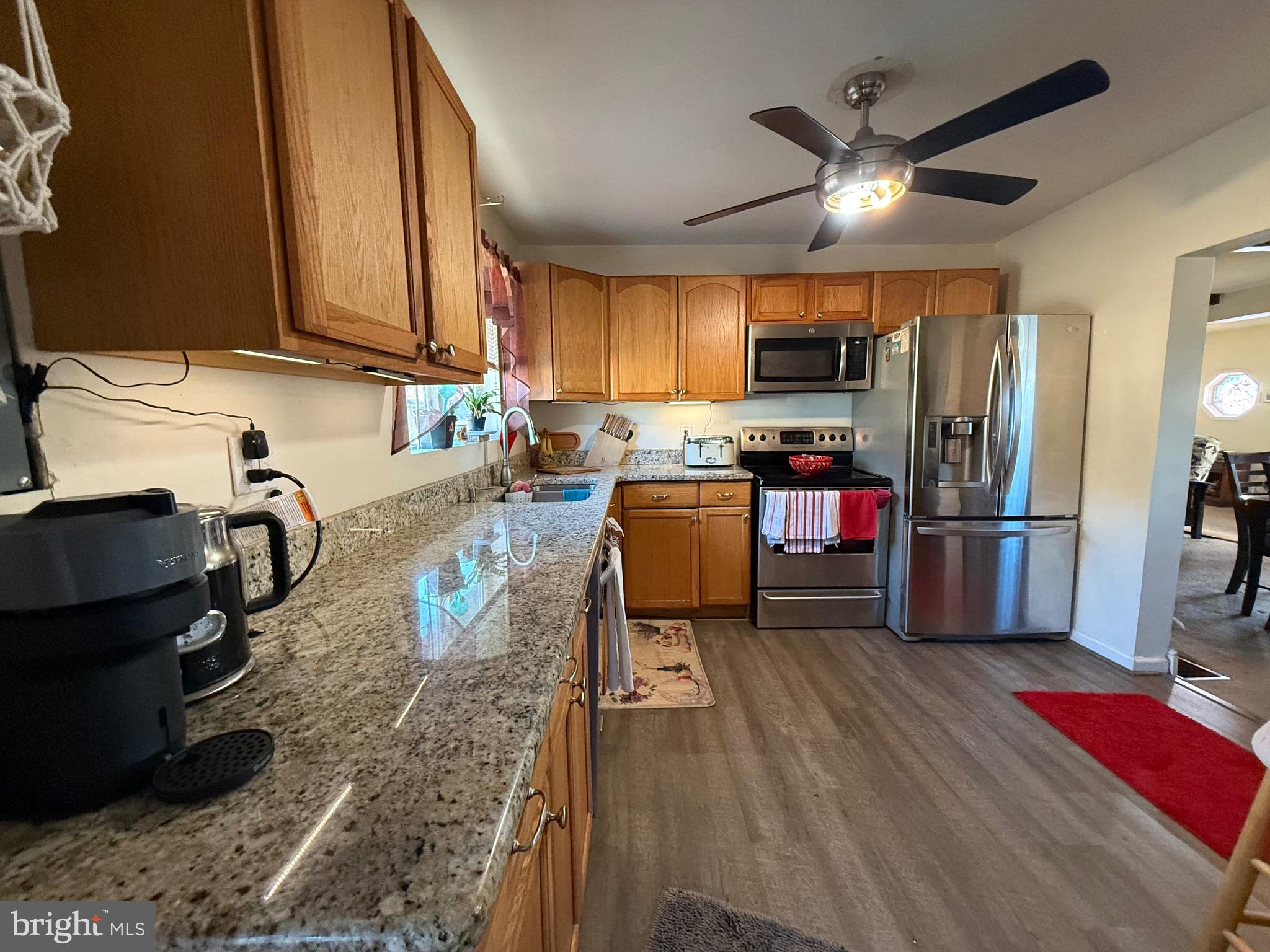 243 C Street Carneys Point, NJ 08069 - Photo 13 of 21 a kitchen with granite countertop a stove top oven a sink dishwasher and a refrigerator with wooden floor