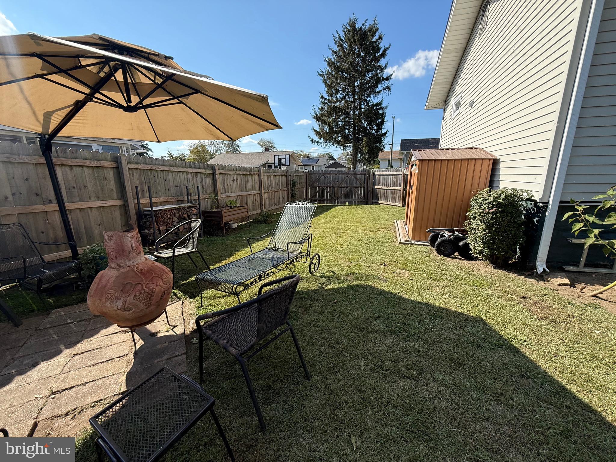 243 C Street Carneys Point, NJ 08069 - Photo 6 of 21 a view of backyard with table and chairs and wooden fence