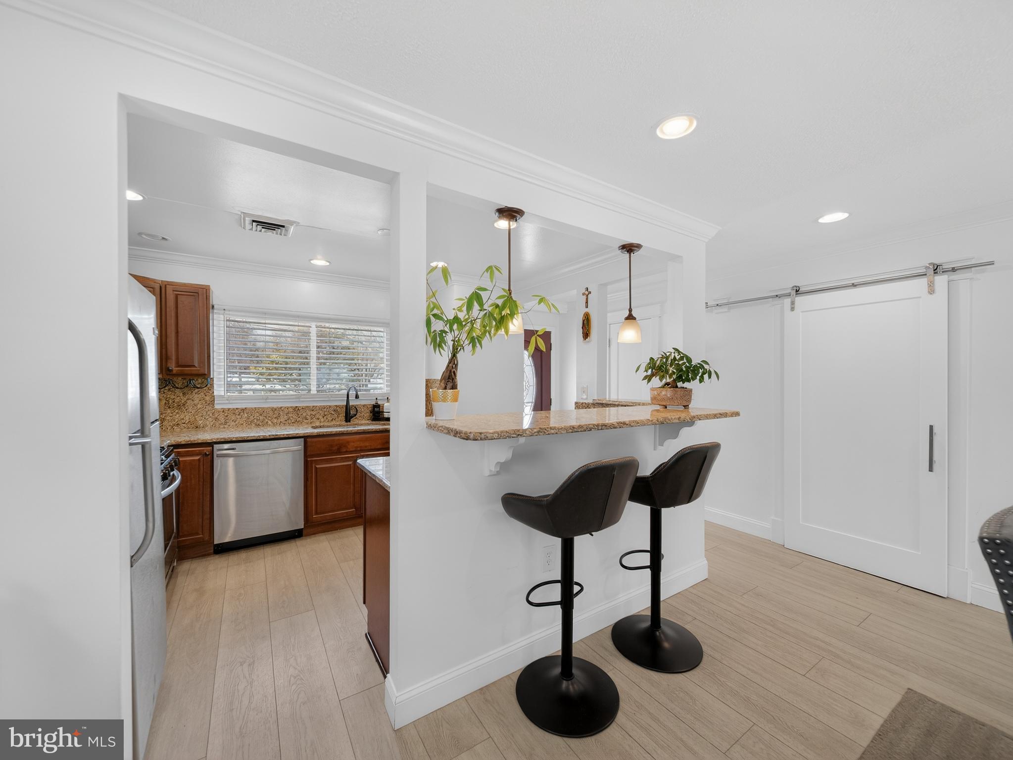 609 Cedarleaf Avenue Capitol Heights, MD 20743 - Photo 12 of 42 a kitchen with stainless steel appliances kitchen island granite countertop a table chairs and a refrigerator