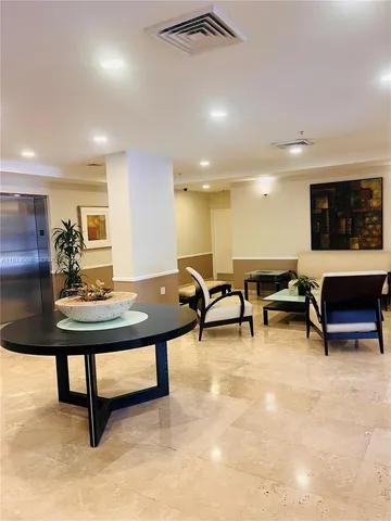 a living room with furniture a flat screen tv and a table