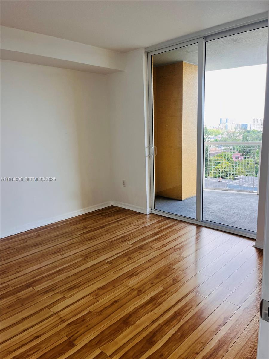 900 Southwest 8th Street, Unit 806 Miami, FL 33130 - Photo 4 of 22 a view of empty room with wooden floor and fan