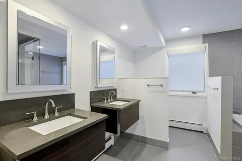 a bathroom with a sink double vanity granite and a mirror