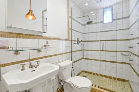 a bathroom with a sink a toilet and shower