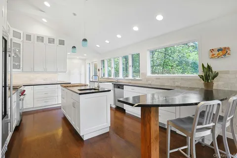 a kitchen with granite countertop a stove and white cabinets