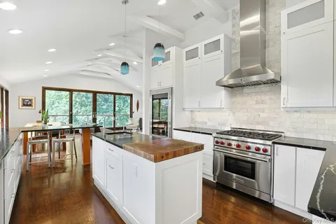 a kitchen with stainless steel appliances granite countertop a stove a sink and a refrigerator