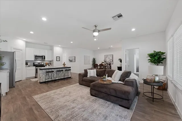 a living room with furniture kitchen view and a potted plant