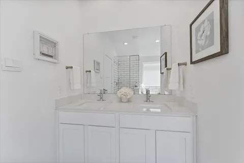 a bathroom with double sink and a mirror