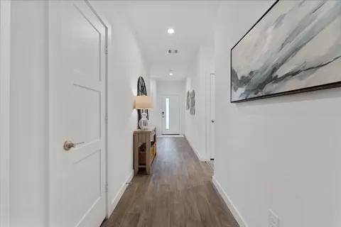 a view of a hallway with wooden floor and staircase