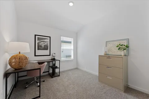 a room with a table chairs and a window