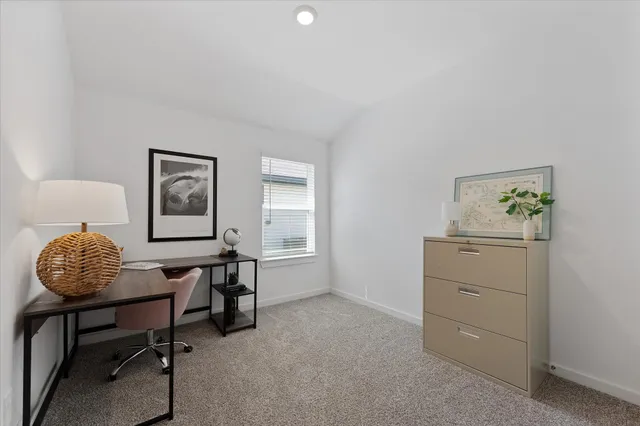 a room with a table chairs and a window