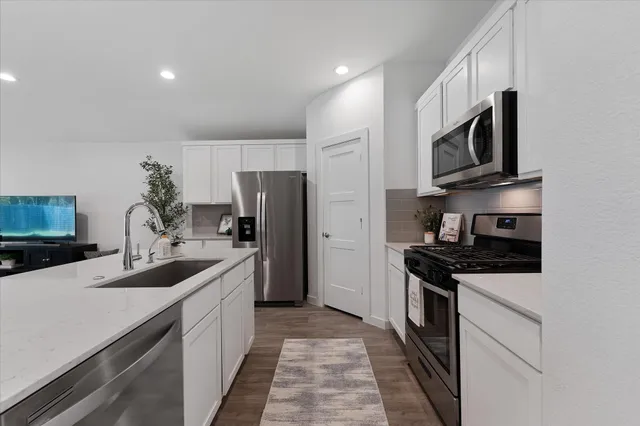 a kitchen with stainless steel appliances a sink stove and refrigerator
