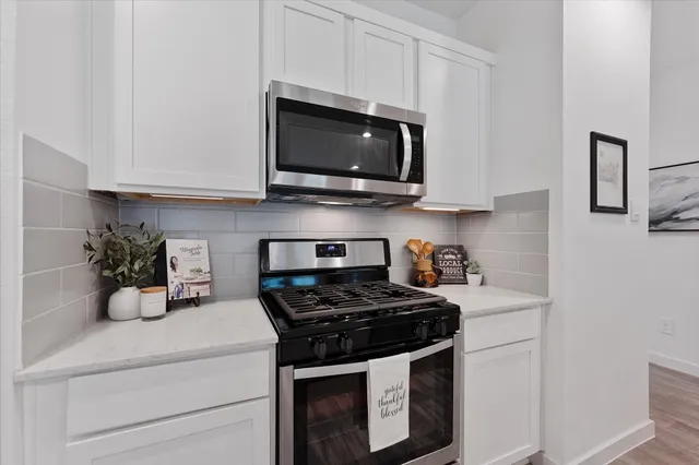 a kitchen with stainless steel appliances a stove a microwave a sink and cabinets
