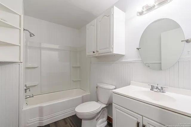 a bathroom with a sink toilet vanity and shower