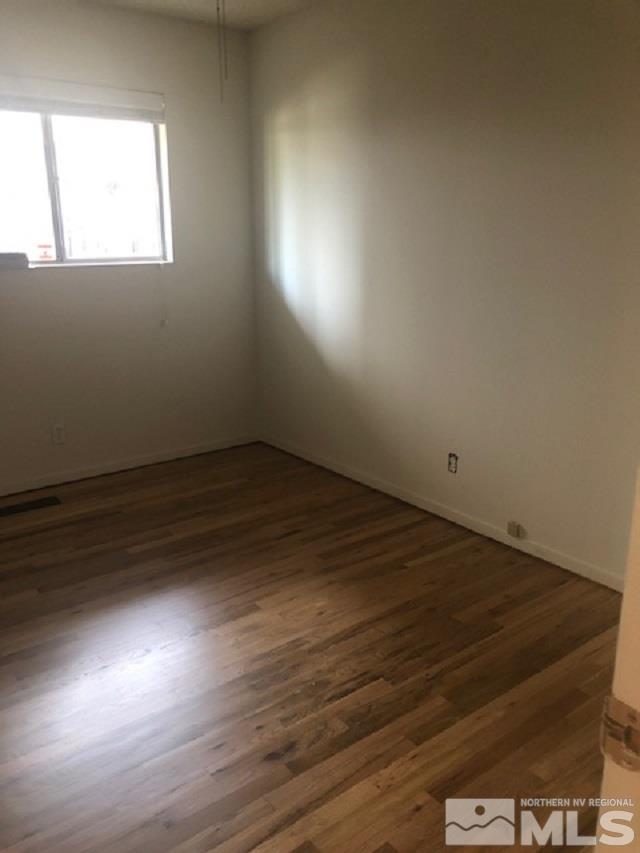 1875 Windsor Way Reno, NV 89503 - Photo 6 of 6 an empty room with wooden floor and windows
